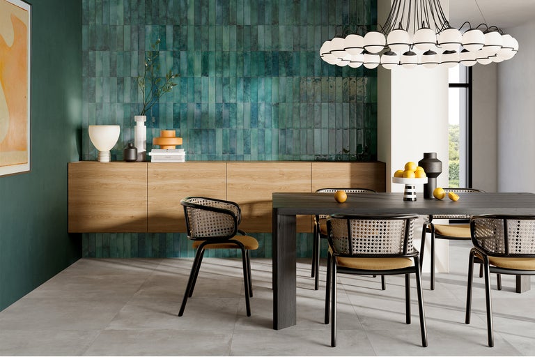 Moderne eetkamer met groene wandtegels, houten vloer en eettafel met stoelen.
