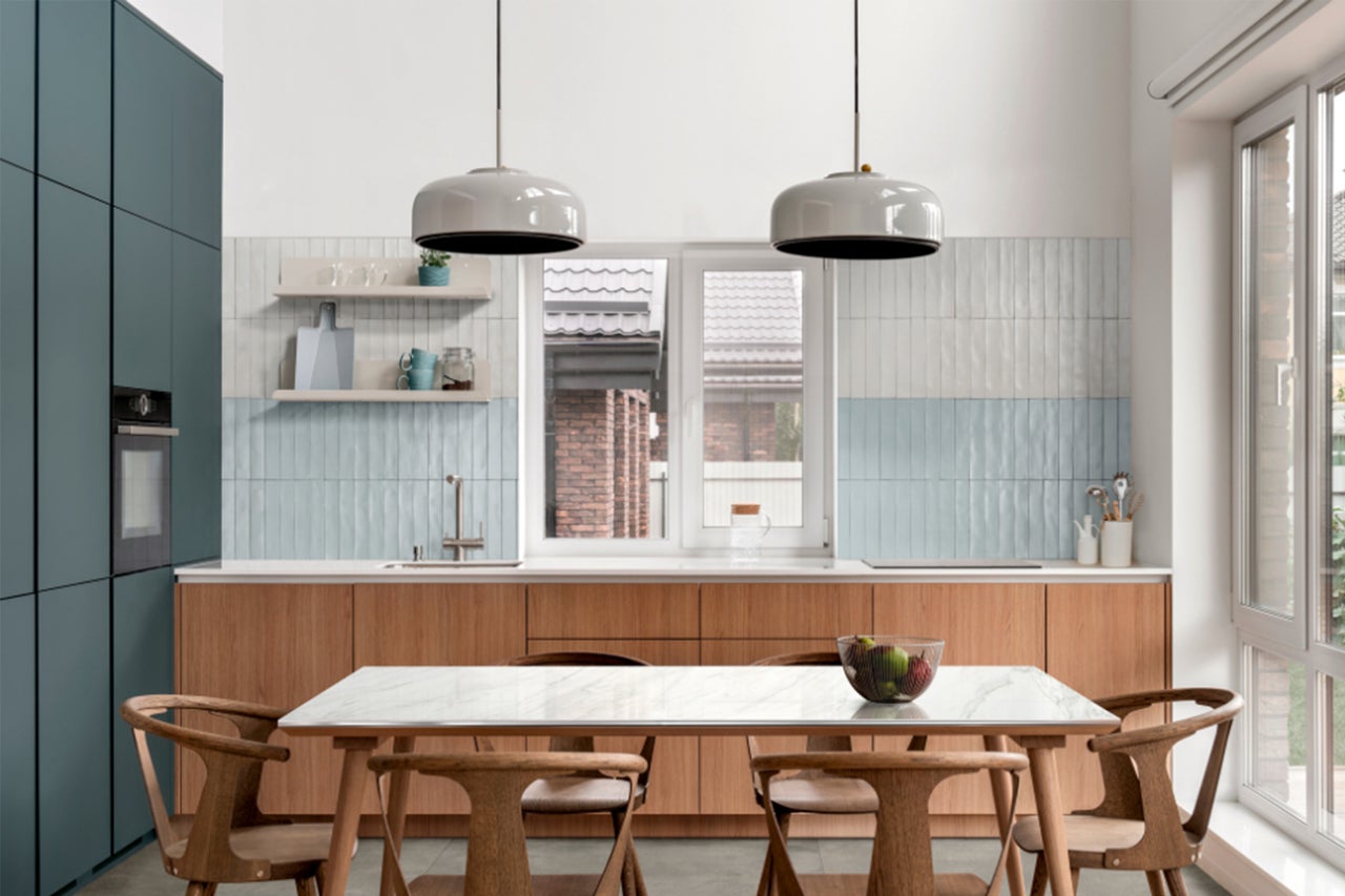 Lichte keuken met eettafel en stoelen, keukenkasten en verlichting