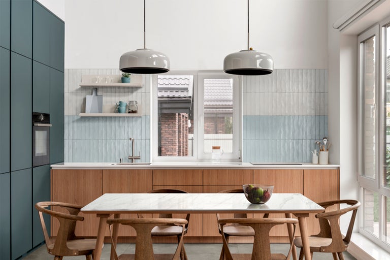 Lichte keuken met eettafel en stoelen, keukenkasten en verlichting