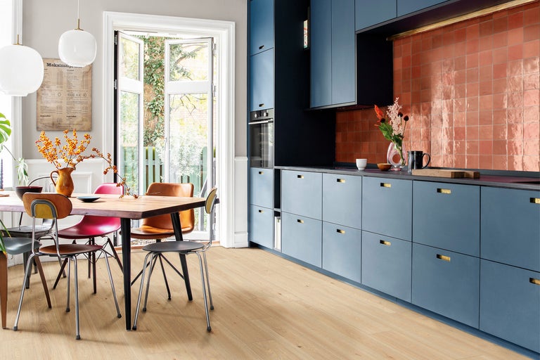 Lichte keuken met houten vloer, eettafel en blauwe keukenkasten