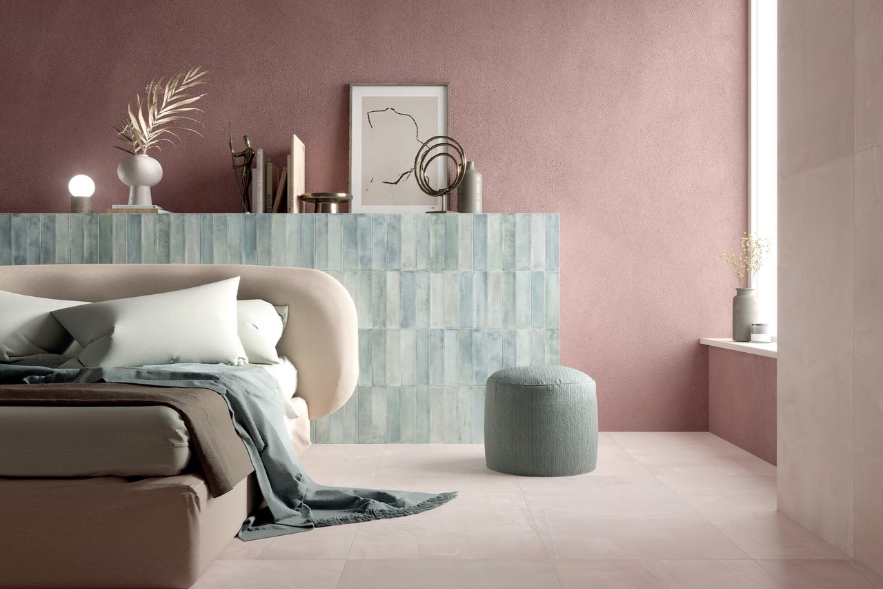 Slaapkamer met bed, nachtkastje en decoratie in roze en blauwe tinten