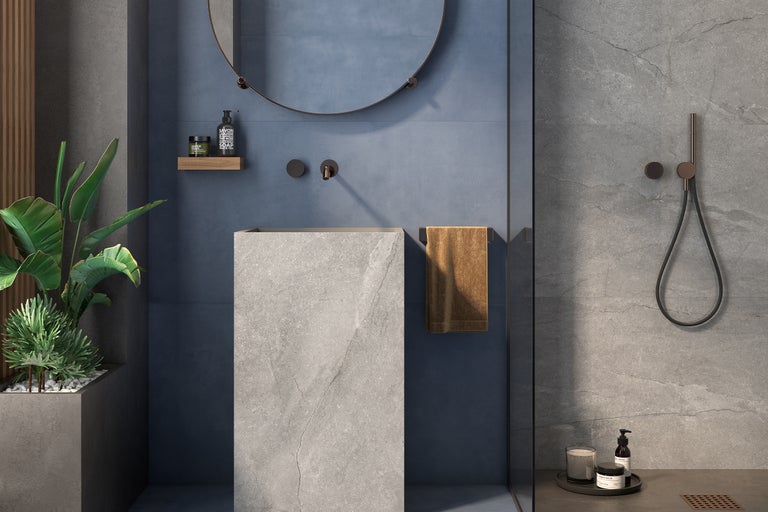 Moderne badkamer met vrijstaande wastafel, ronde spiegel, handdoek en douchearmatuur.
