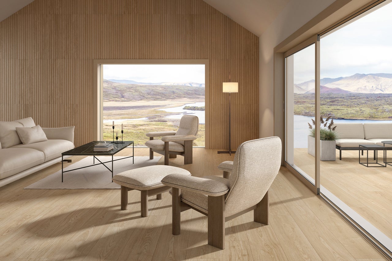 Lichte woonkamer met bank, fauteuil en uitzicht op het landschap