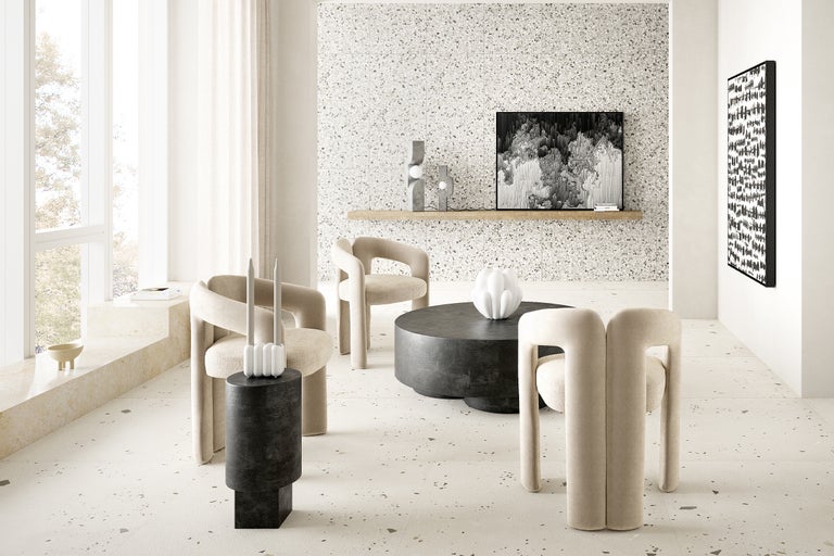 Lichte woonkamer met terrazzo vloer, fauteuils, salontafel en decoratie