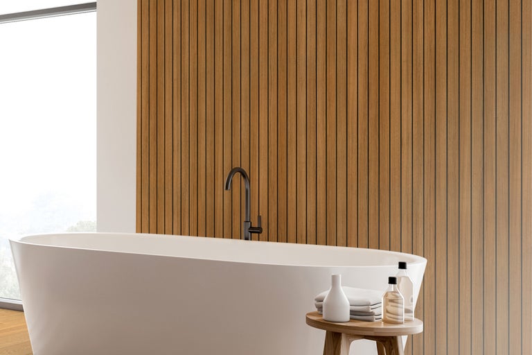 Lichte badkamer met bad, houten lambrisering en decoratie
