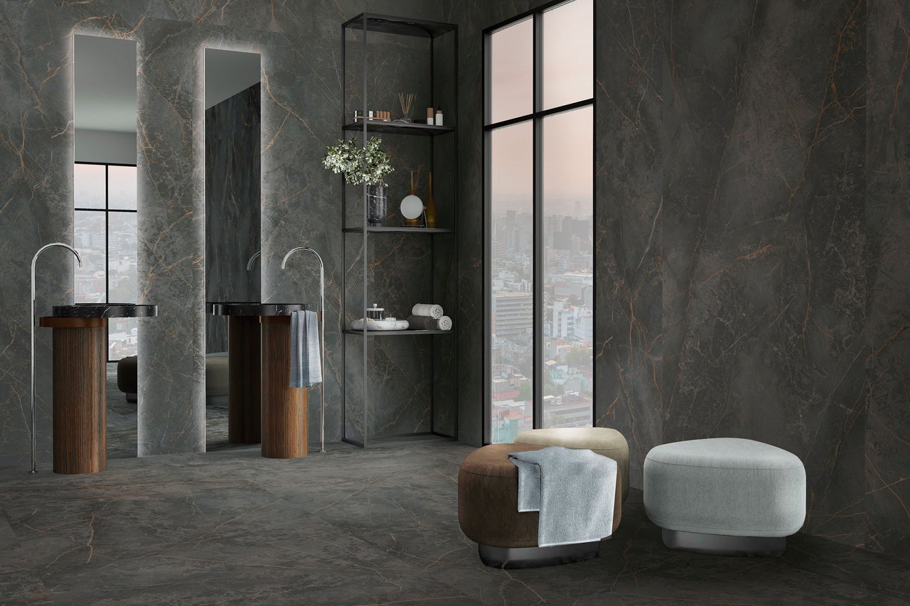 Moderne badkamer met grootformaat wand- en vloertegels in donker marmerlook, twee wastafels op houten zuilen en hoge spiegels.