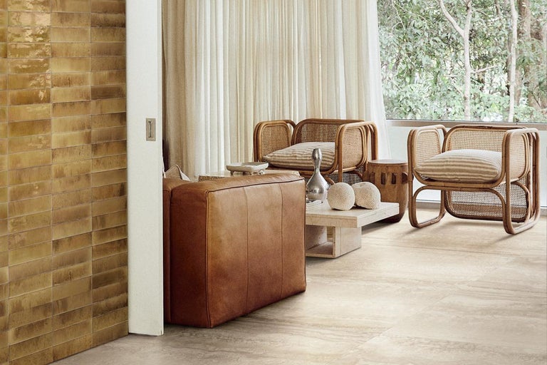 Lichte woonkamer met rotan stoelen, leren bank en tegels