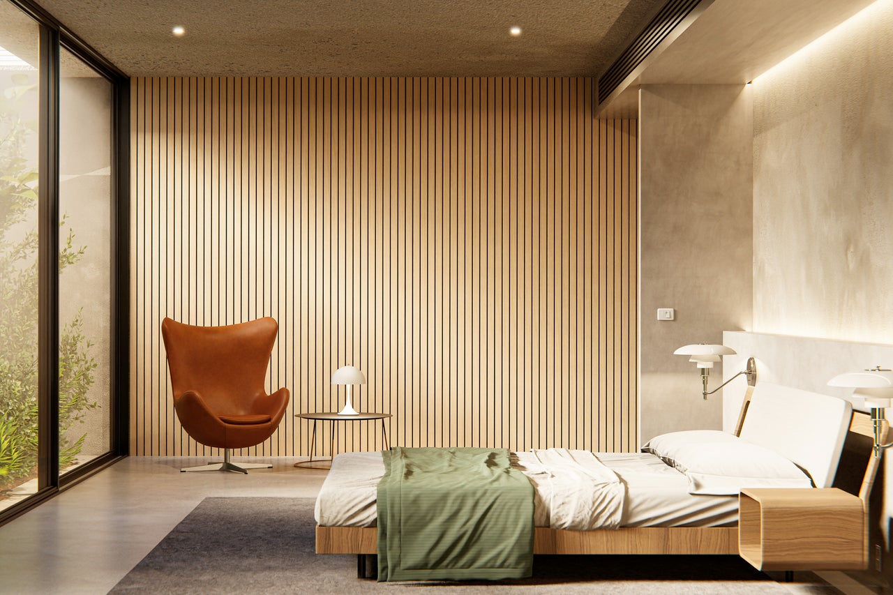 Lichte slaapkamer met groot raam, fauteuil en houten wand