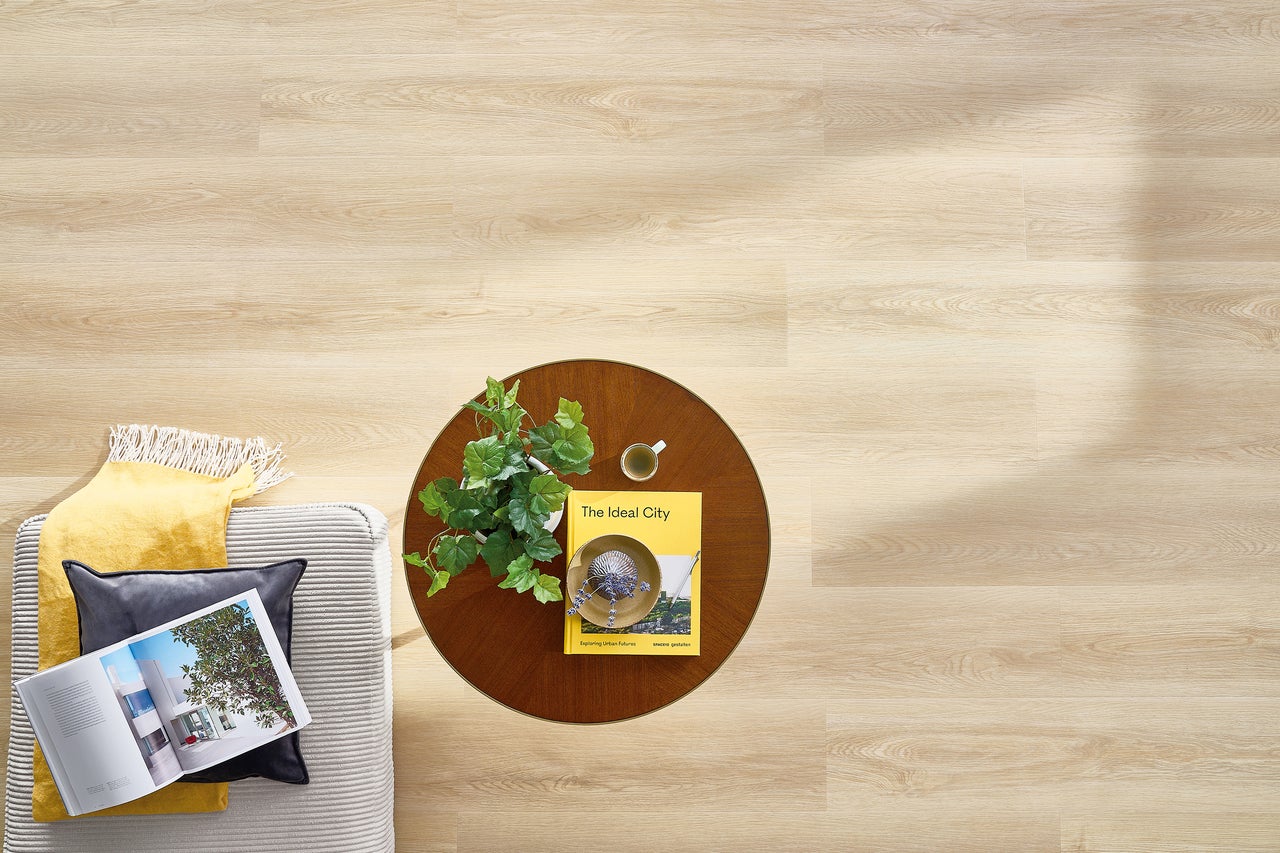 Lichte houten vloer met bank, tafel en decoratie van bovenaf