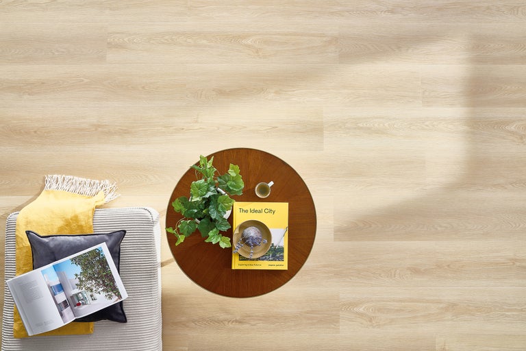 Lichte houten vloer met bank, tafel en decoratie van bovenaf