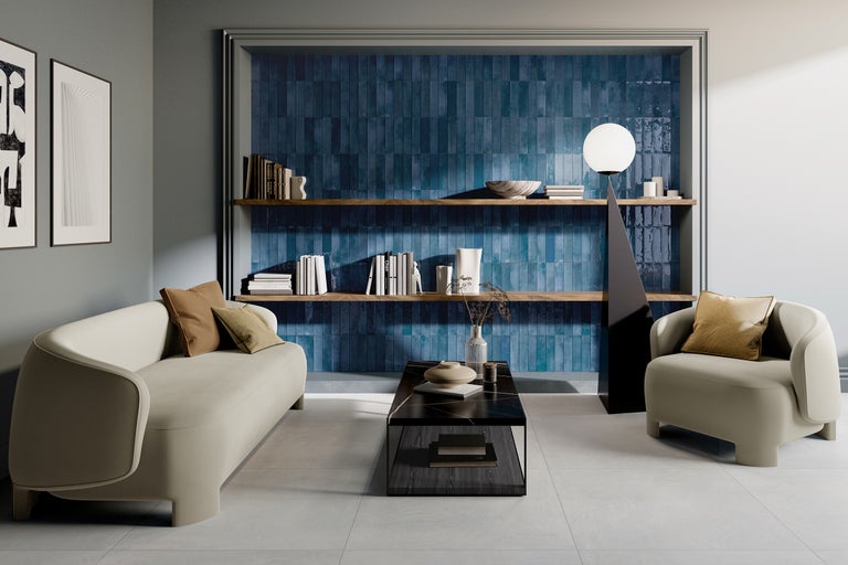 Woonkamer met bank, fauteuil, salontafel, planken en blauwe wandtegels