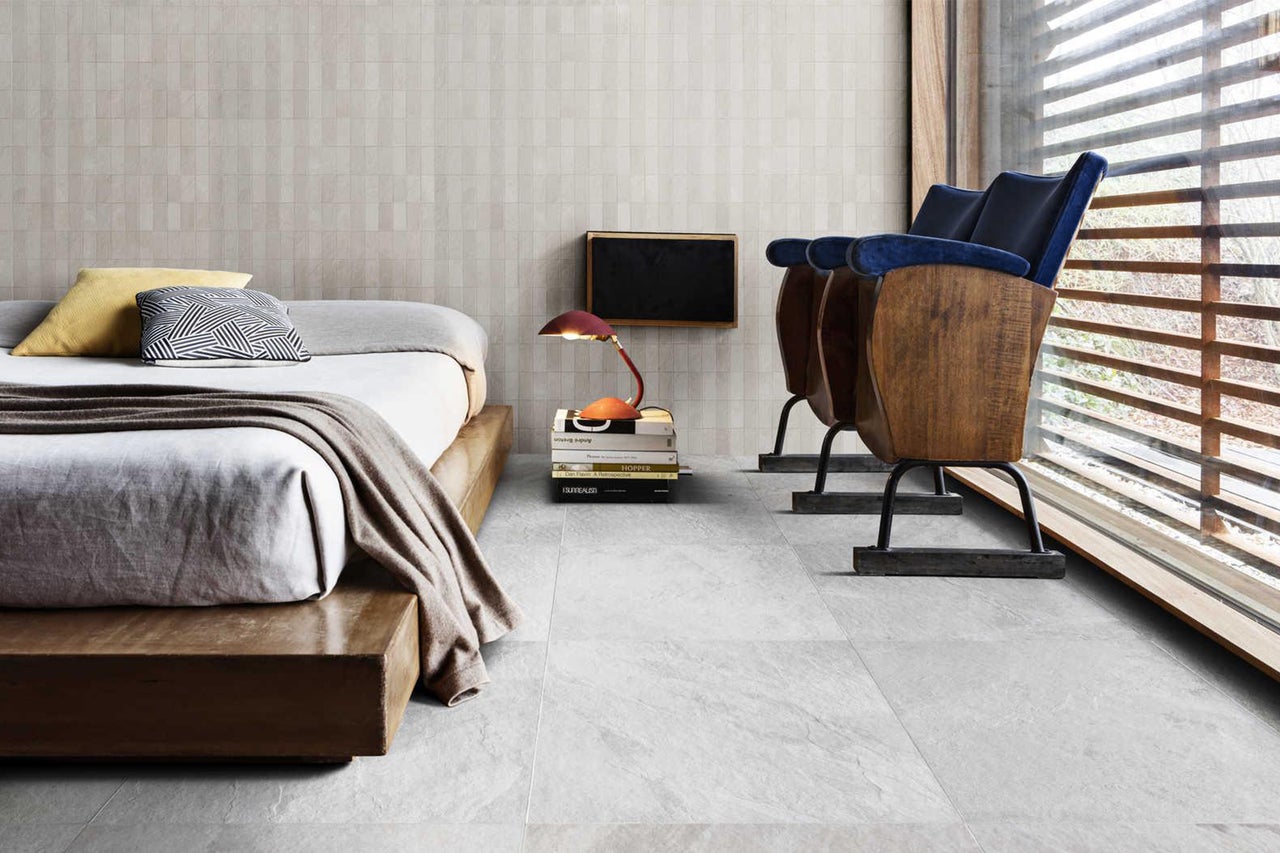 Lichte kamer met bed, twee bioscoopstoelen, wand- en vloertegels