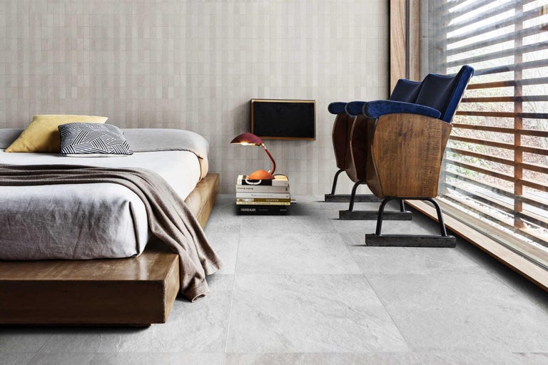 Lichte kamer met bed, twee bioscoopstoelen, wand- en vloertegels