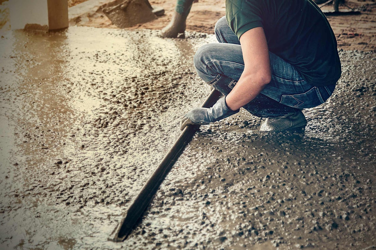 Persoon maakt beton glad met een werktuig