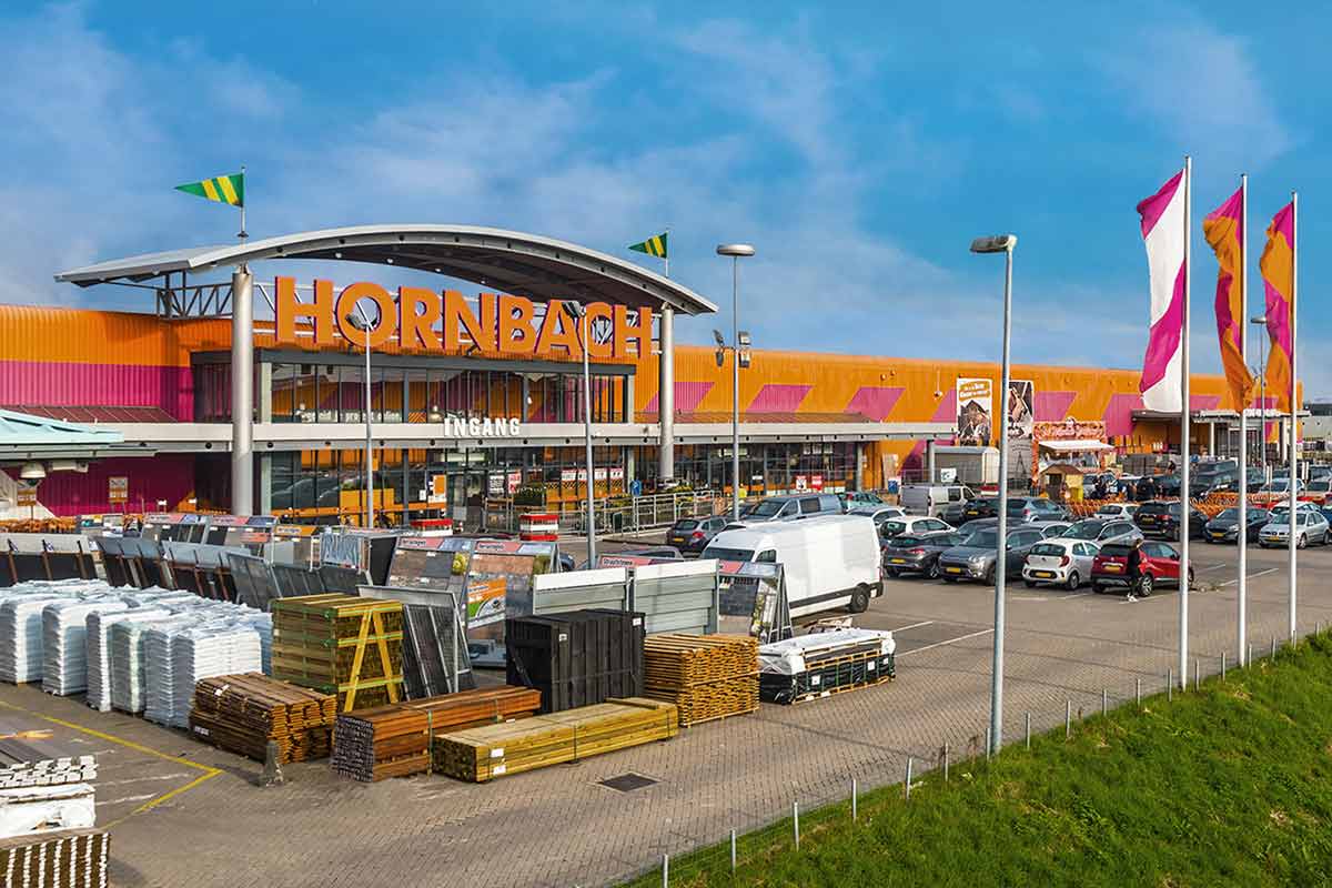 Buitenaanzicht van een Hornbach bouwmarkt met parkeerplaats en goederenassortiment
