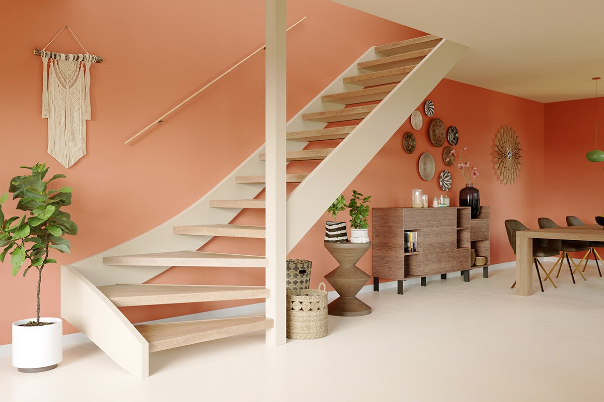 Lichte woonkamer met houten trap, dressoir en decoratie