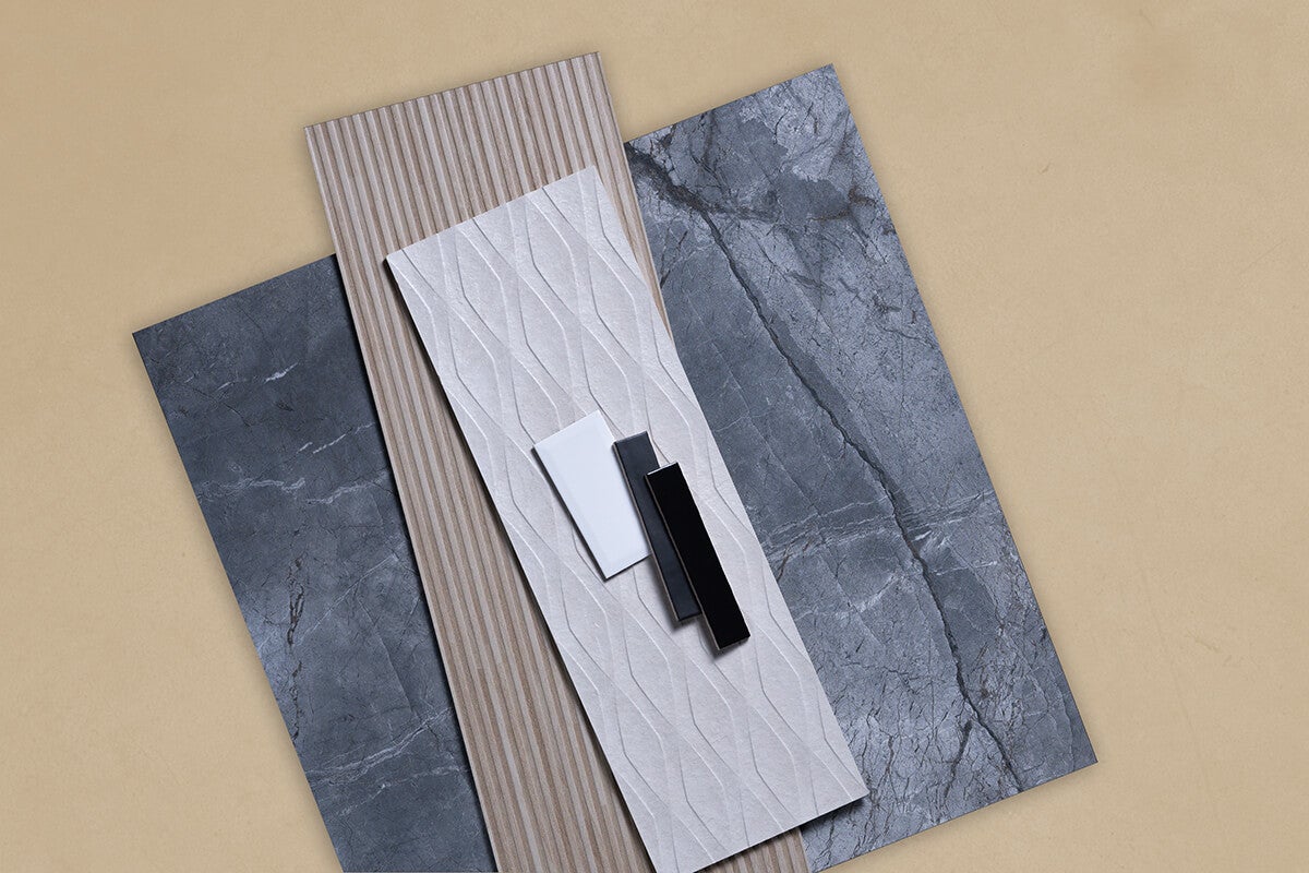 Assortiment wandtegels en vloertegels in marmerlook, houtoptiek en met reliëfstructuur plus kleine accenttegels.