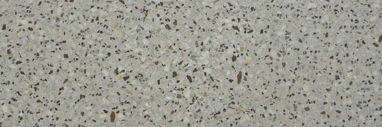 Terrazzo tegels met gestructureerd oppervlak en ingewerkte steenfragmenten voor vloerbekleding.