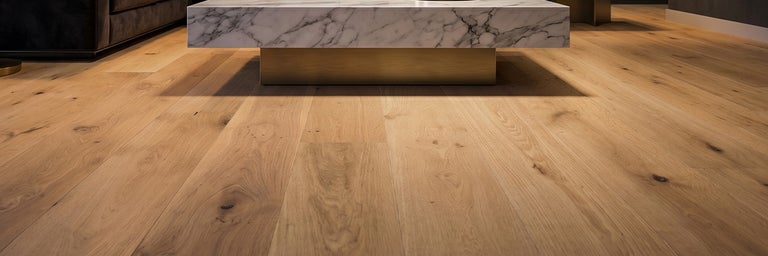 Eikenhouten vloerdelen in een moderne woonkamer met marmeren tafel en zichtbare houtnerf.