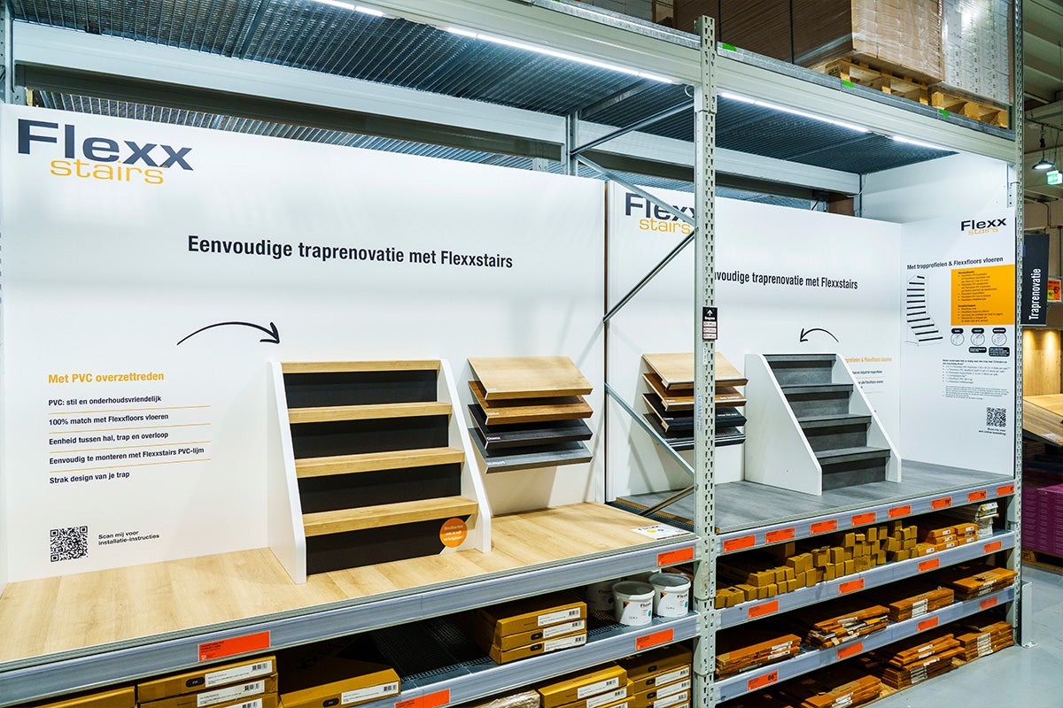 Flexx stairs verkoopdisplay voor traprenovatie met overzettreden en materiaalmonsters in een lichte, georganiseerde winkelstelling.
