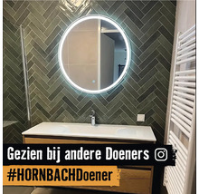 Badkamer met wastafel, spiegel met verlichting en handdoekradiator.