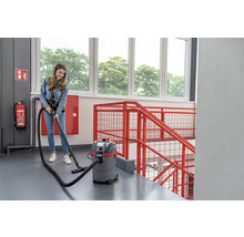Een vrouw gebruikt een nat- en droogzuiger in een trappenhuis.