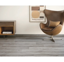 Lichte kamer met vinylvloer in houtlook, fauteuil en dressoir