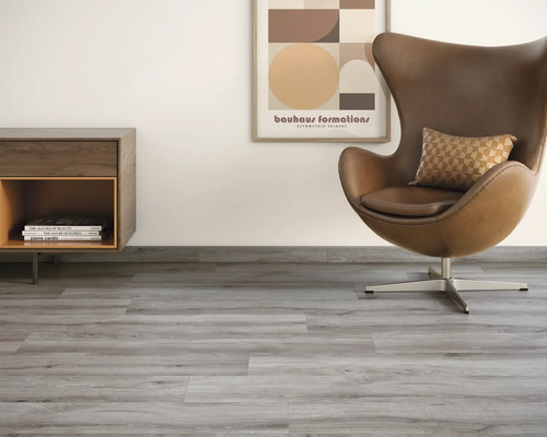 Lichte kamer met vinylvloer in houtlook, fauteuil en dressoir