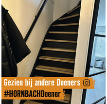 Trap met houten treden en zwarte leuning binnenshuis