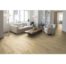 Lichte woonkamer met houten vloer, bank, fauteuil en plank.
