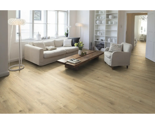 Lichte woonkamer met houten vloer, bank, fauteuil en plank.
