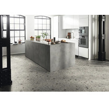 Moderne keuken met kookeiland, witte kasten en terrazzo vloer.