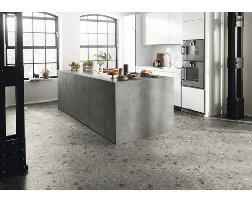 Moderne keuken met kookeiland, witte kasten en terrazzo vloer.