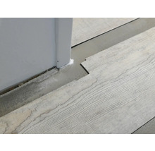 Installatie van vinylvloer met houtlook naast een muur