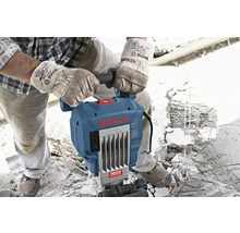Een bouwvakker met handschoenen bedient een Bosch GSH 16 Professional breekhamer op een bouwplaats.