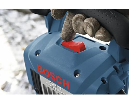 Hand met handschoen bedient de rode schakelaar van een blauwe Bosch breekhamer.