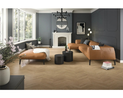 Ruime moderne woonkamer met vloer met houtlook in visgraatmotief, wanden met sierlijsten, een grote leren bank en een schouw.