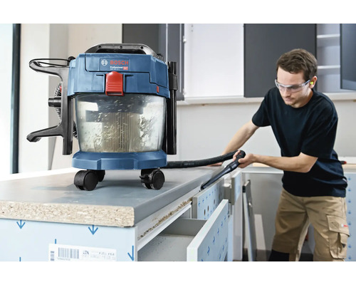 Bosch accu nat- en droogzuiger in gebruik voor het reinigen van een werkbank in een lichte werkplaats.