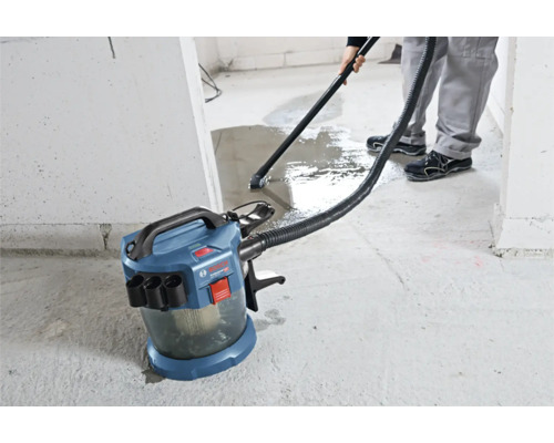 Bosch Professional accu nat- en droogzuiger bij het opzuigen van water op een betonnen vloer.