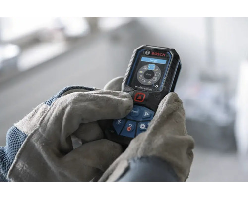 Bosch Professional laserafstandsmeter bediend door handen in werkhandschoenen, digitaal display met meetfuncties.