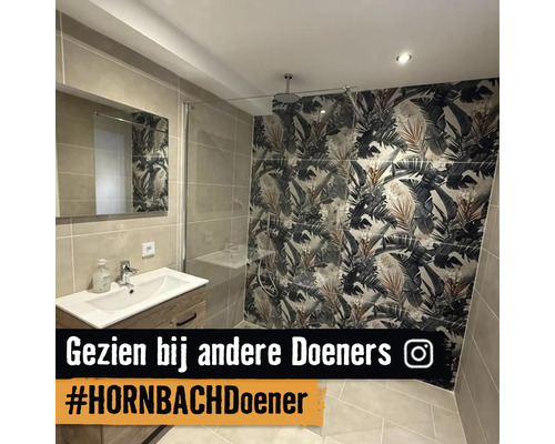 Moderne badkamer met houten wastafelmeubel, inloopdouche met glazen wand en accentmuur met tropisch bladmotief.