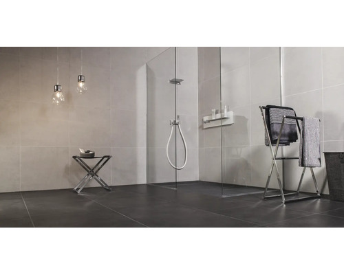 Moderne badkamer met inloopdouche van glas, betegelde muren, handdoekrek en twee hanglampen in een minimalistisch ontwerp.