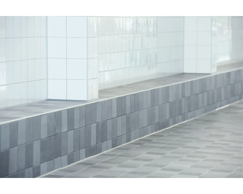 Wand- en vloertegels in een moderne badkamer met vierkante wandtegels en rechthoekige vloertegels in een strakke uitstraling