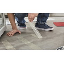Persoon legt designvloer met dubbelzijdige tape