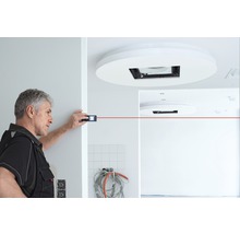 Ambachtsman meet een kamer met een laser afstandsmeter.