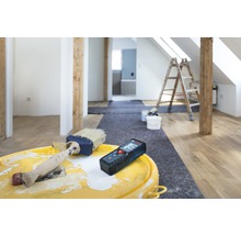 Kamerrenovatie met laser afstandsmeter, verf en penseel op een emmer