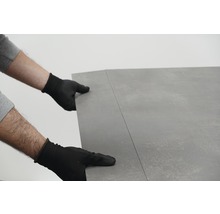Persoon met handschoenen legt vloerbedekking