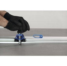 Tegelsnijder in gebruik met handschoenen op aluminium geleiderail