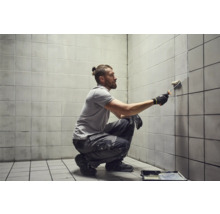 Man schildert tegelwand met verfroller