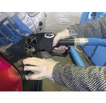 Een persoon met handschoenen tankt diesel in een auto.
